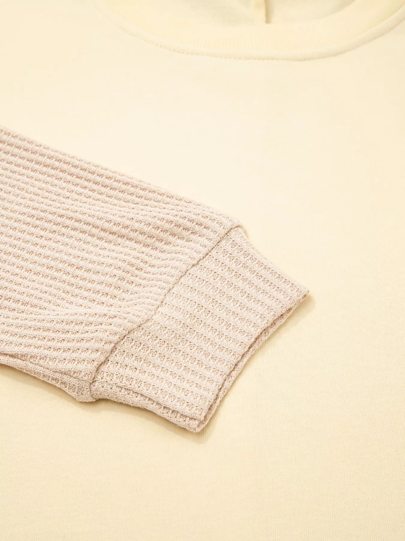 Health Hive beige faux two-piece patchwork sweatshirt with a textured waffle knit sleeve and ribbed cuff detail.