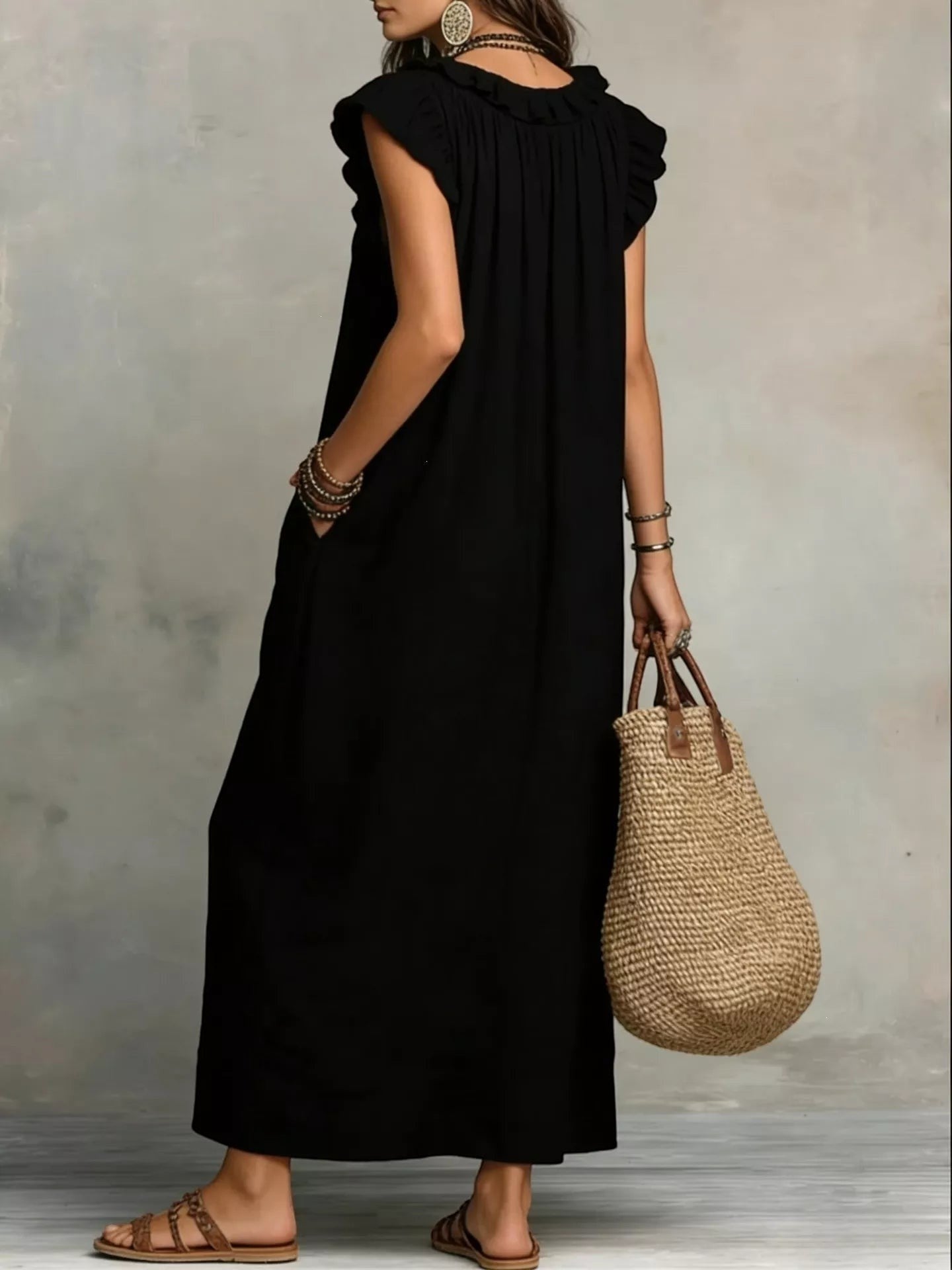 Health Hive black ruffled V-neck maxi dress with cap sleeves and pockets, worn by a model with a straw bag.