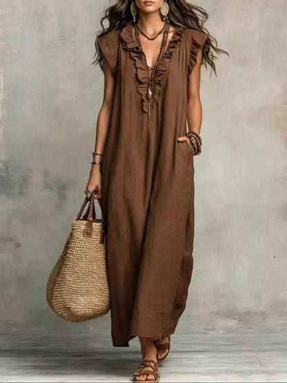 Health Hive brown ruffled V-neck maxi dress with cap sleeves and pockets, styled with a straw tote bag.