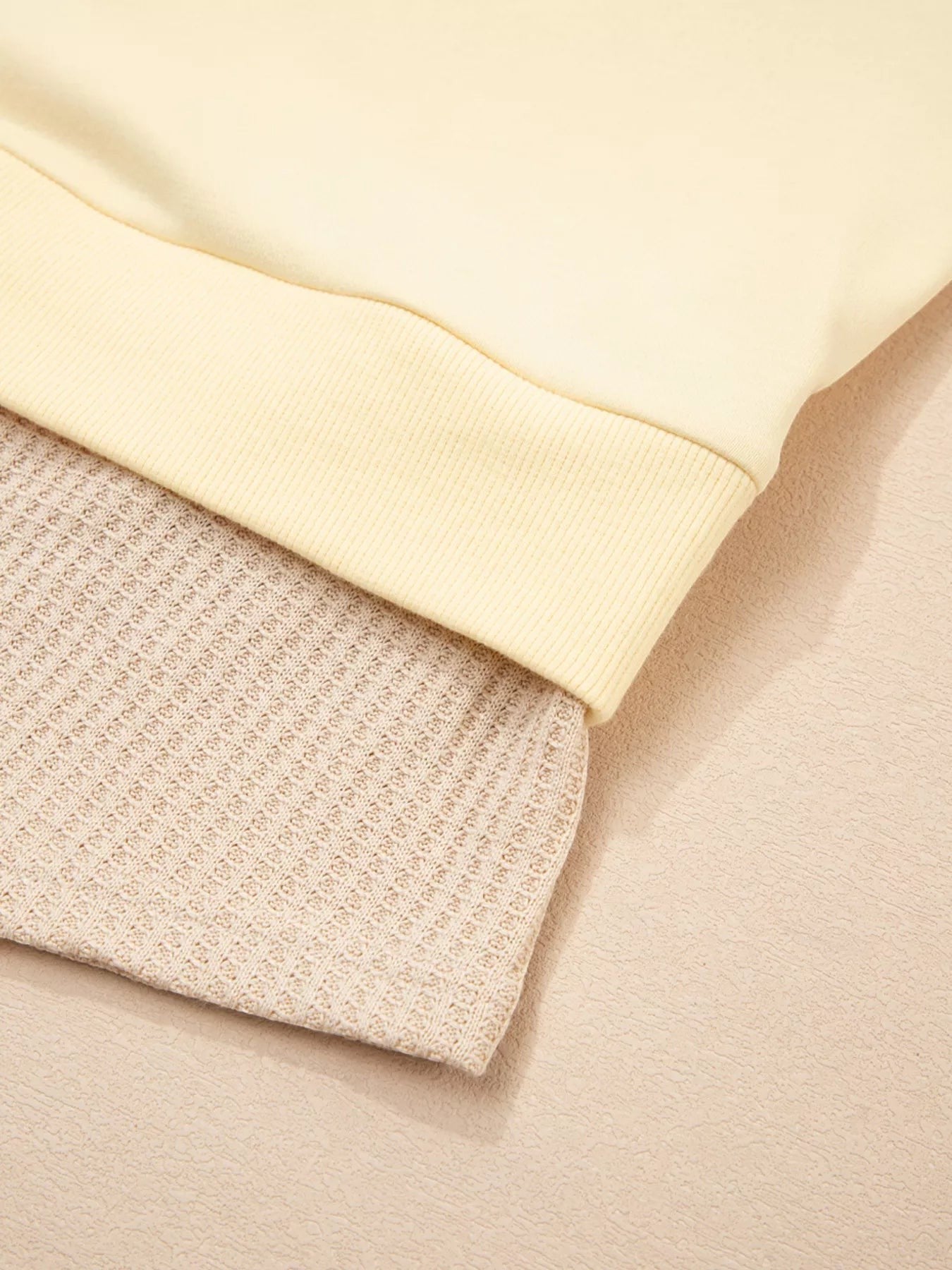 Health Hive 2 in 1 faux two-piece sweatshirt featuring a smooth pale yellow top layer over a textured beige waffle knit.