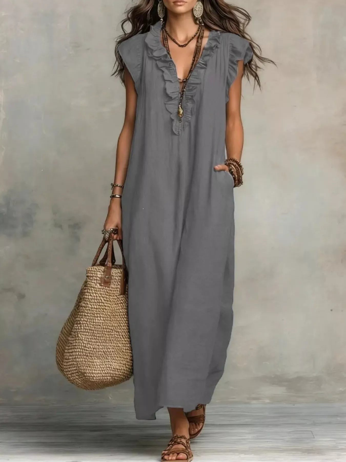 Health Hive grey ruffled V-neck maxi dress with cap sleeves and pockets, styled with a straw bag and sandals.