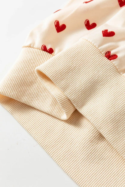 Health Hive cream sweatshirt with red heart print and ribbed cuffs made from a soft polyester blend fabric