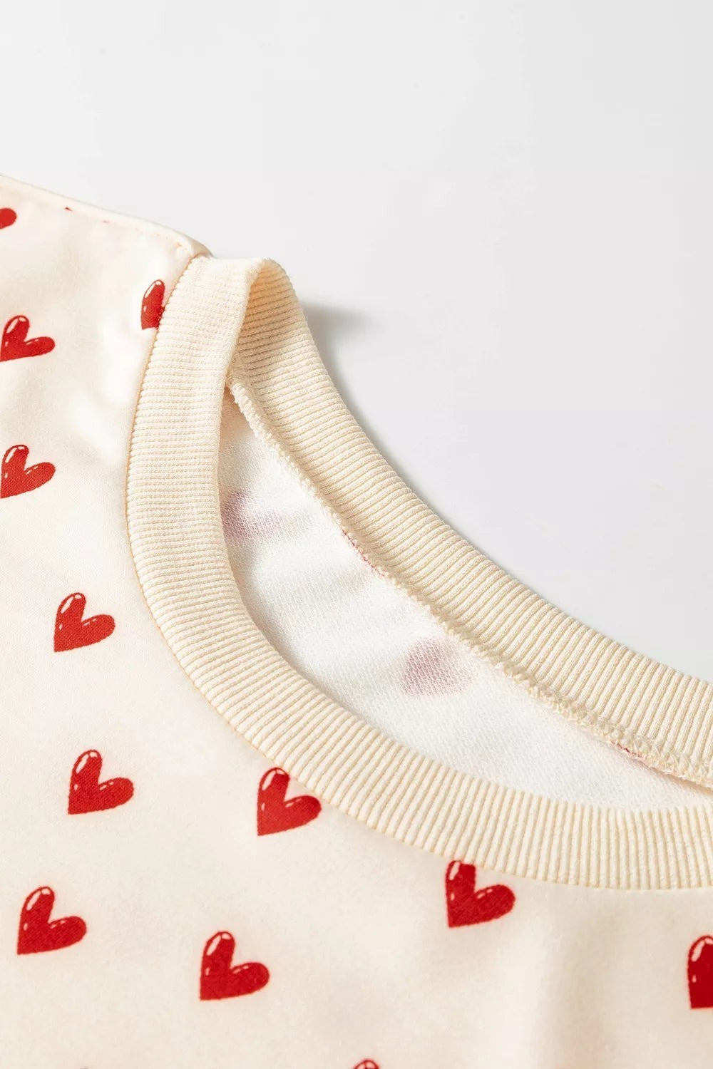Health Hive round neck sweatshirt in cream with a red heart print pattern, featuring ribbed collar detail.