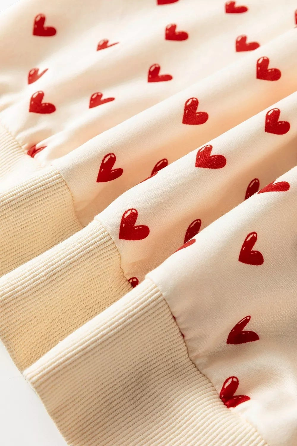 Health Hive cream sweatshirt featuring a red heart print pattern with ribbed cuffs and a soft polyester blend fabric.