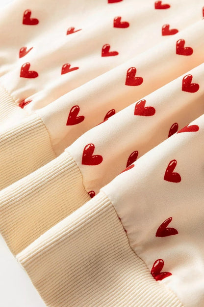 Health Hive cream sweatshirt featuring a red heart print pattern with ribbed cuffs and a soft polyester blend fabric.